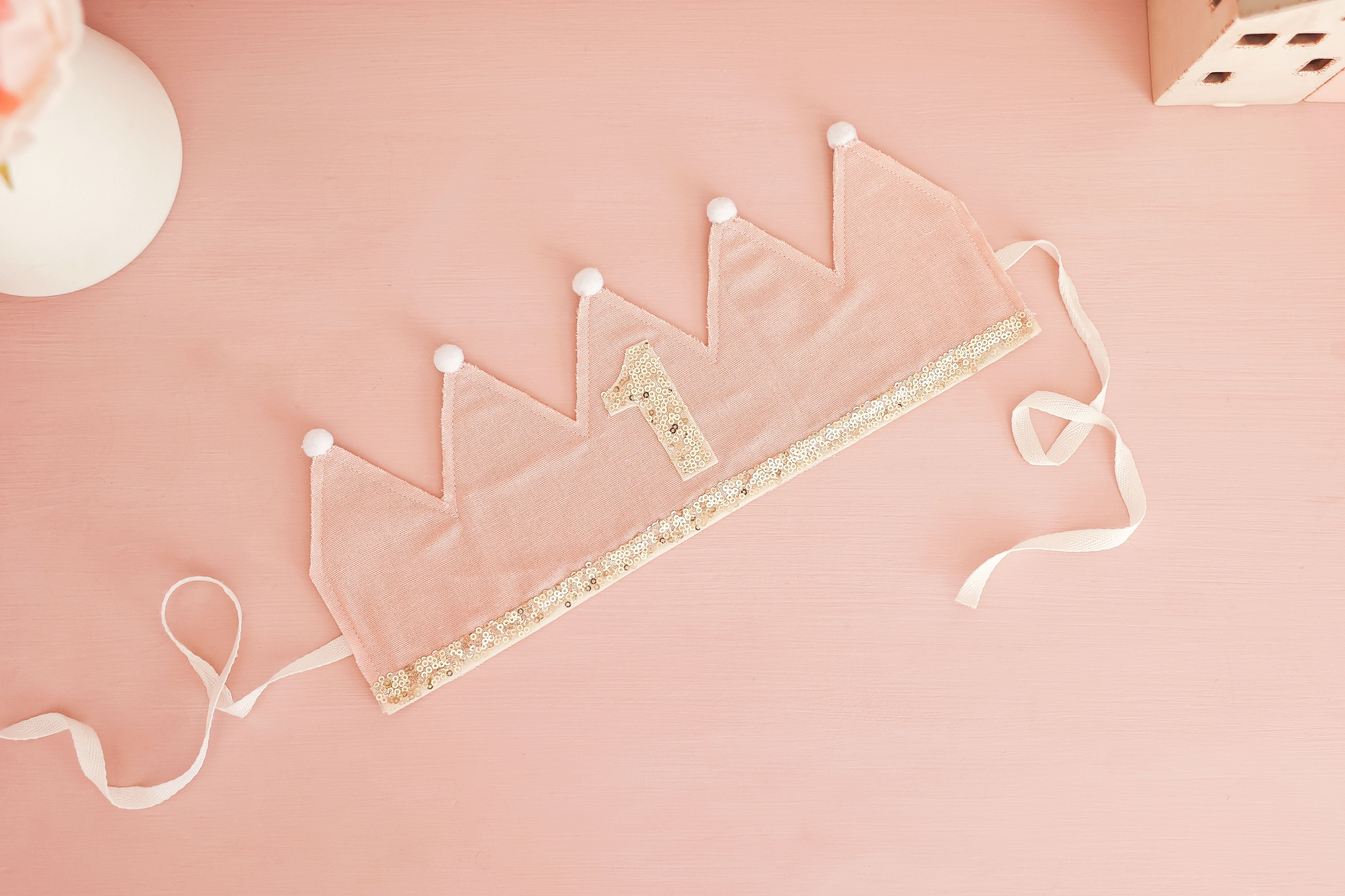 First birthday crown laid flat showing its adjustable ribbon ties