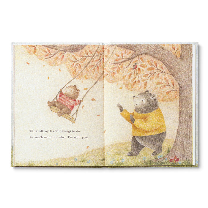 Open spread of the small bear on a tree swing under autumn leaves