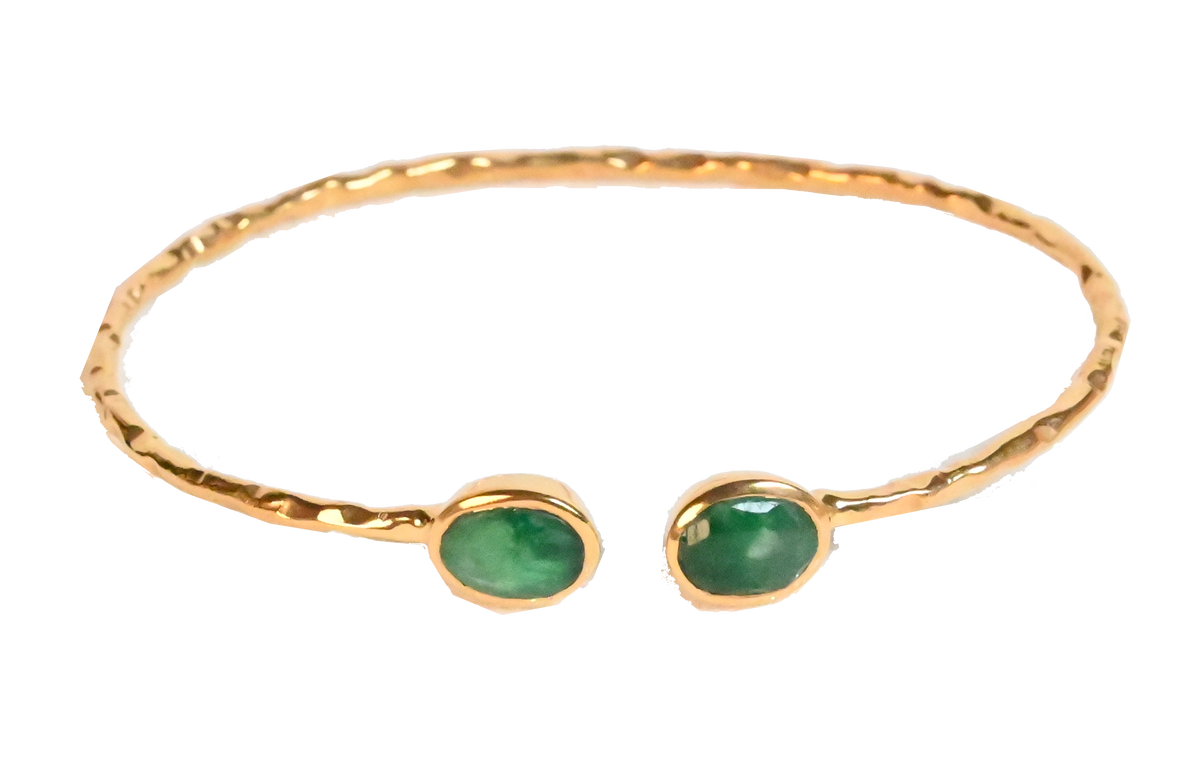 Euro Gold cuff bangle with two emerald-green gems on black background