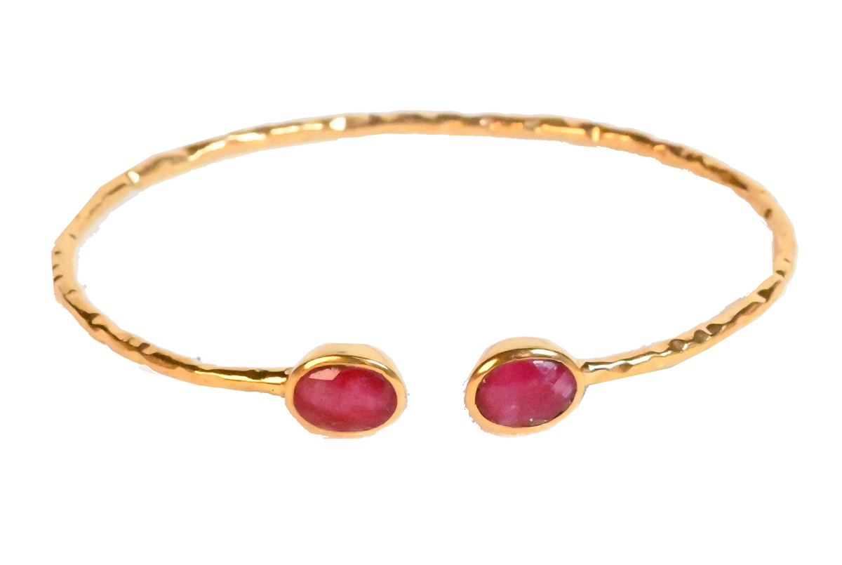 Euro Gold cuff bangle with two ruby-red gems on black background