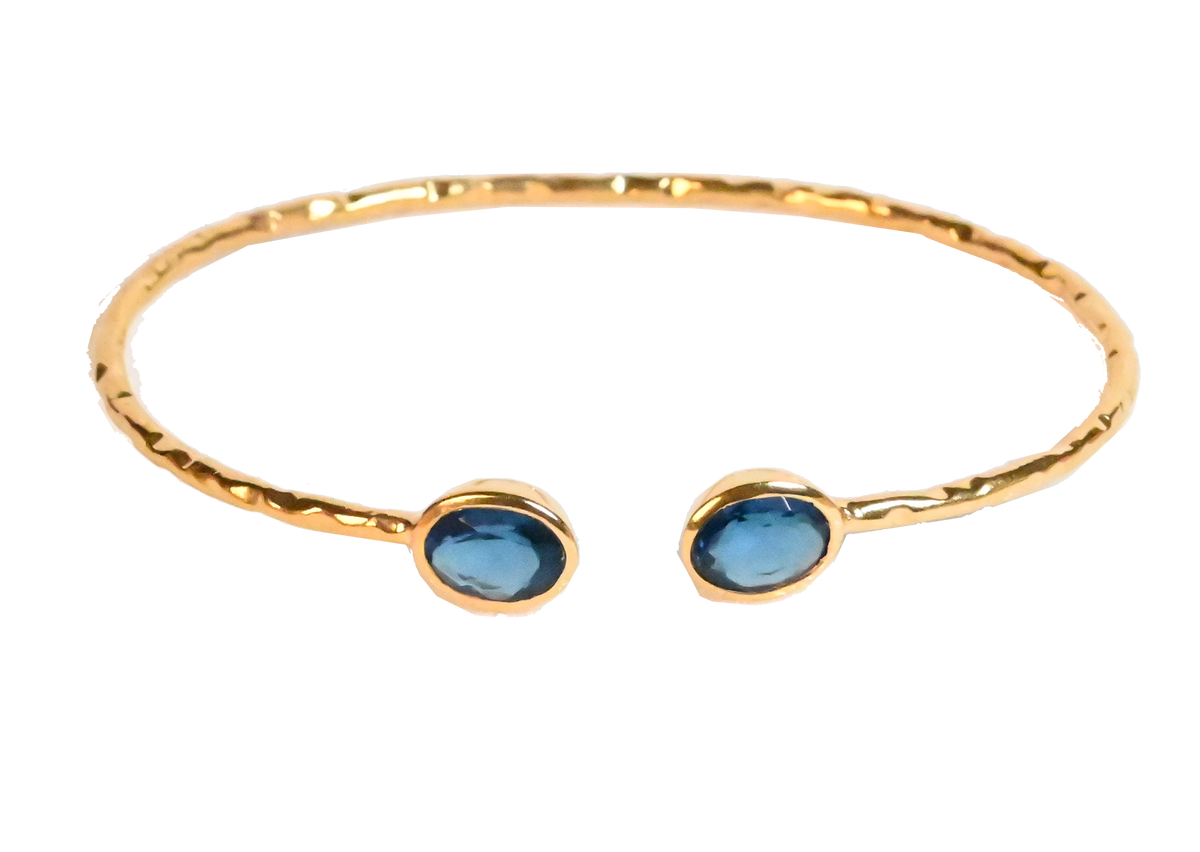 Euro Gold cuff bangle with two London-blue gems on black background