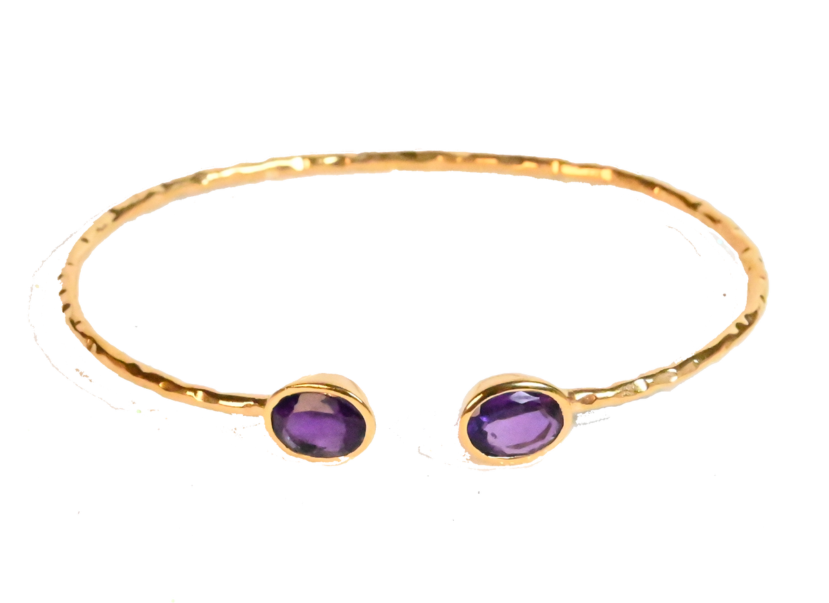 Euro Gold cuff bangle with two amethyst-purple gems on black background