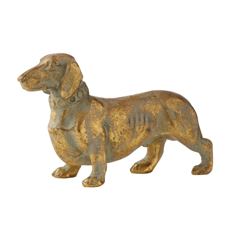Antique gold dachshund figurine in profile facing left, showing its long body and short legs.