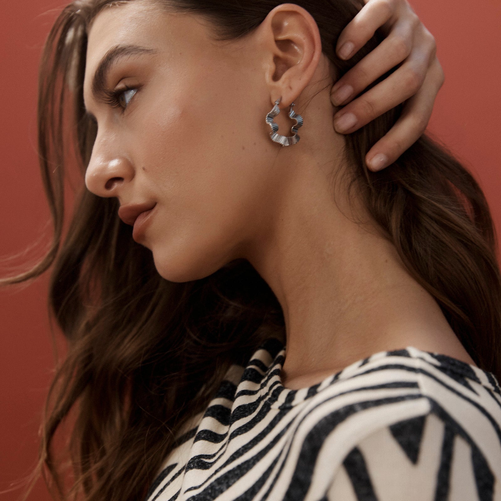 Model in zebra print wearing the silver Himba Scallop Hoop