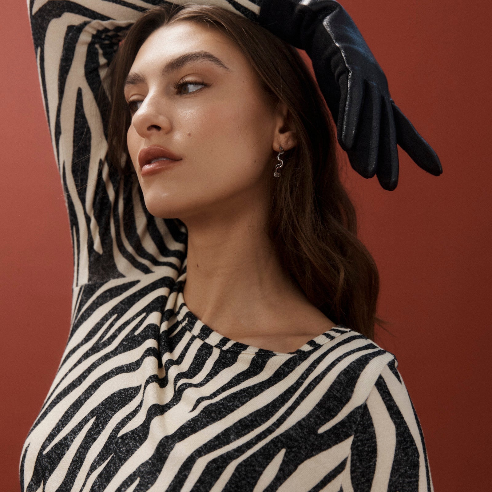 Model posing with arm raised wearing the silver scallop hoops