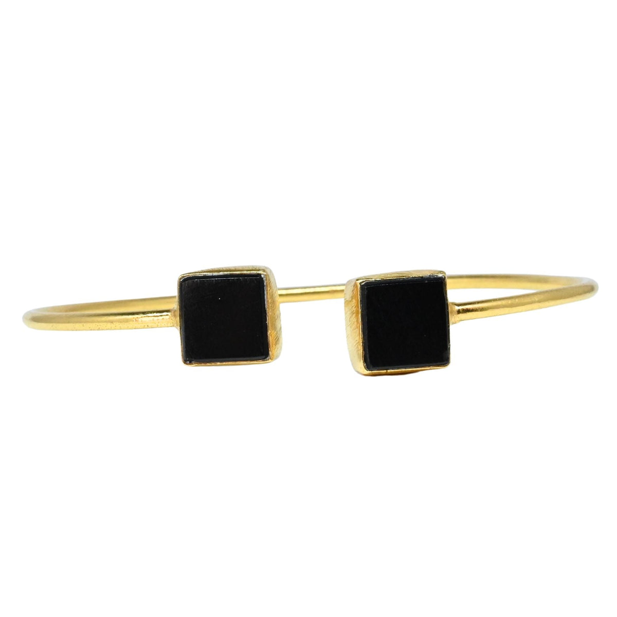 Fine gold cuff bangle with a square black onyx at each end