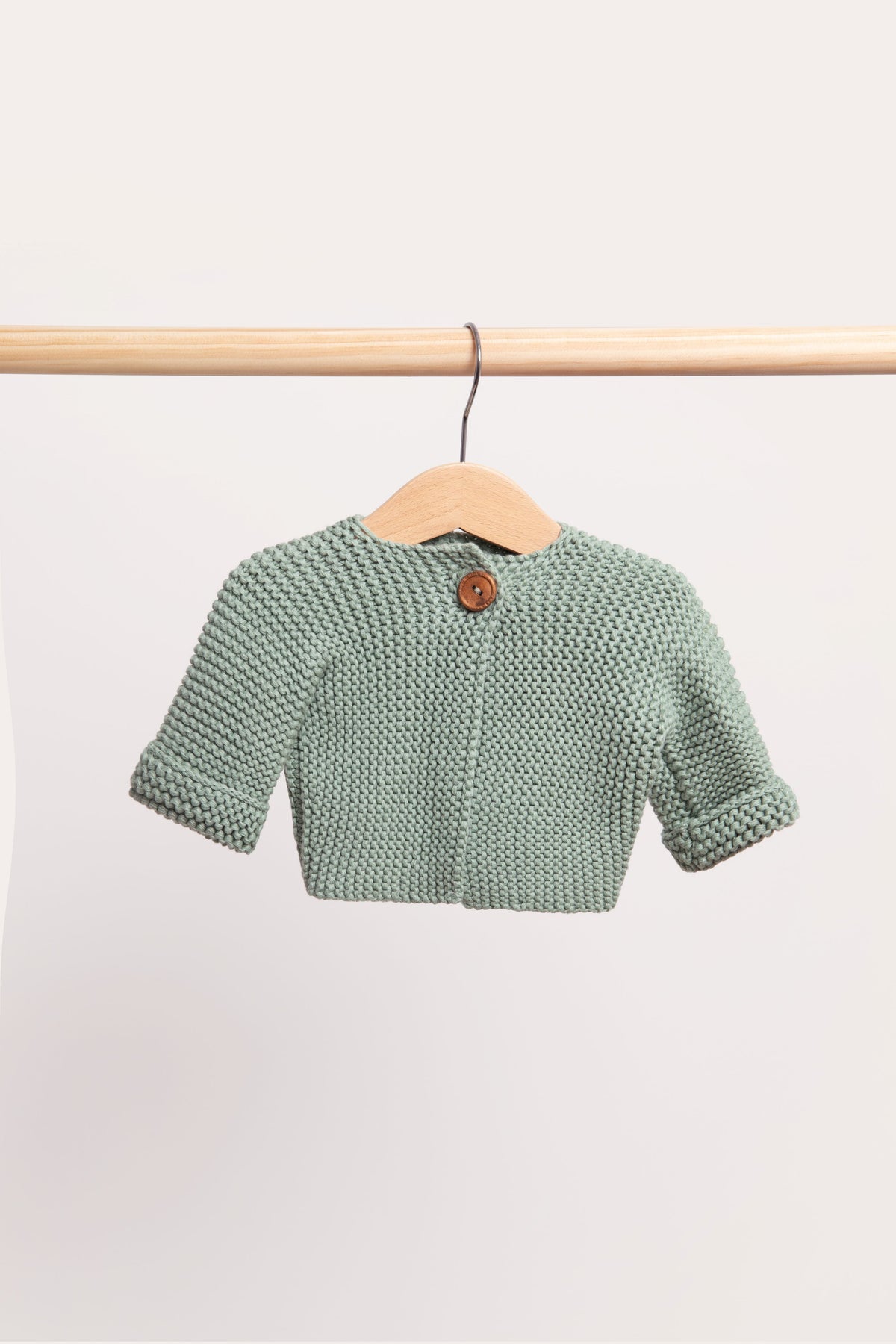 Duck Egg cardigan in a soft grey-green, on a wooden hanger from a timber rail.