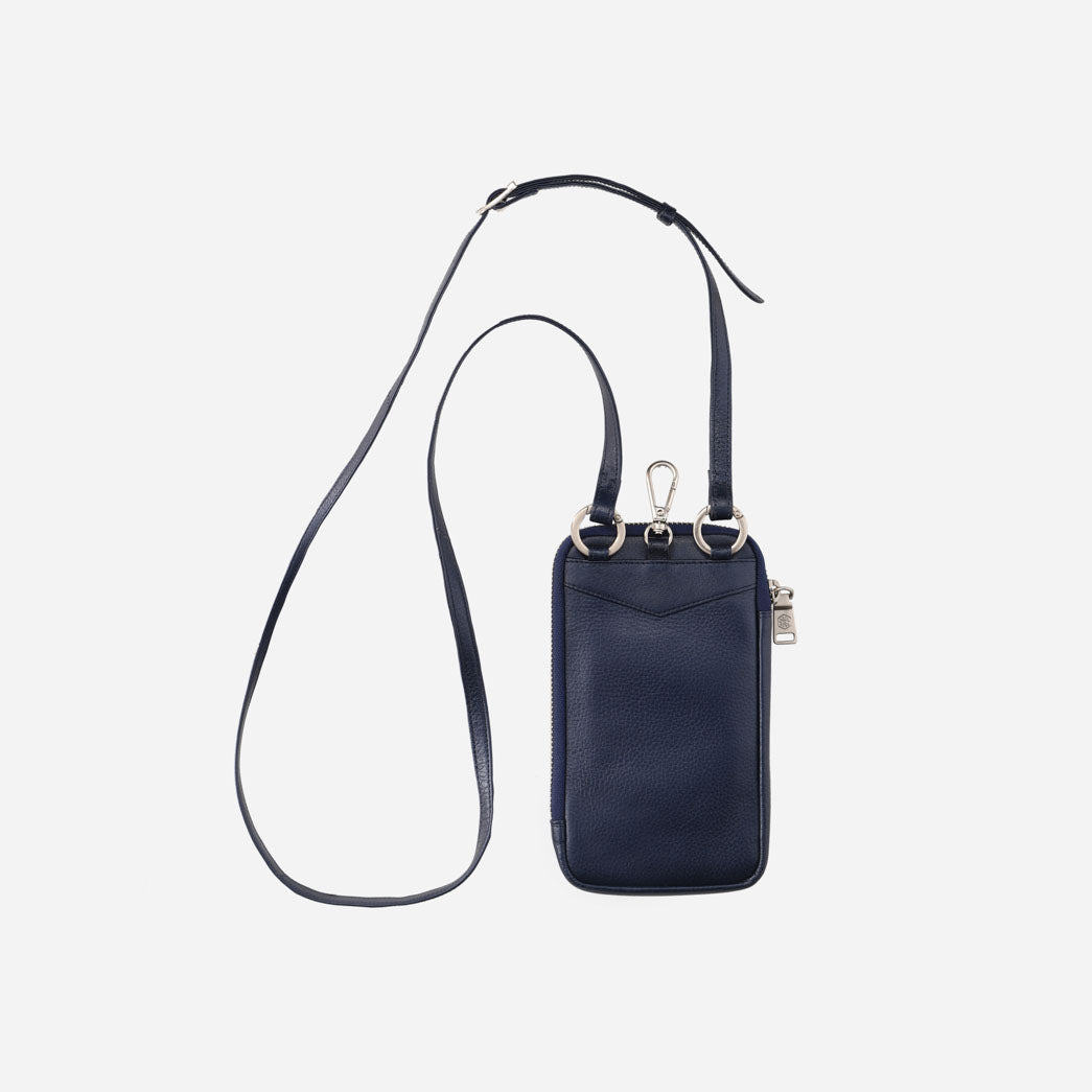 Navy leather phone pouch hanging from its crossbody strap