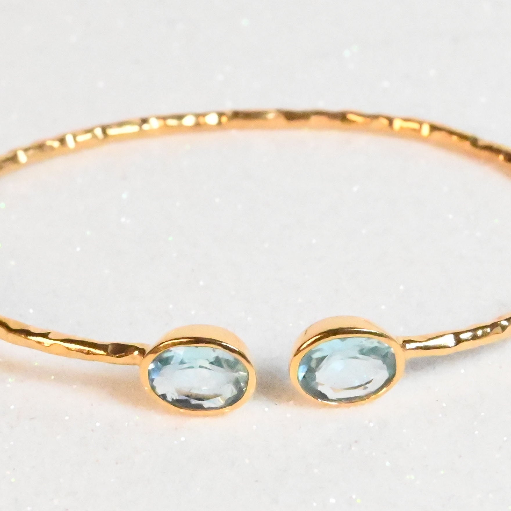 Rose-toned Euro Gold cuff bangle with two pale blue topaz gems