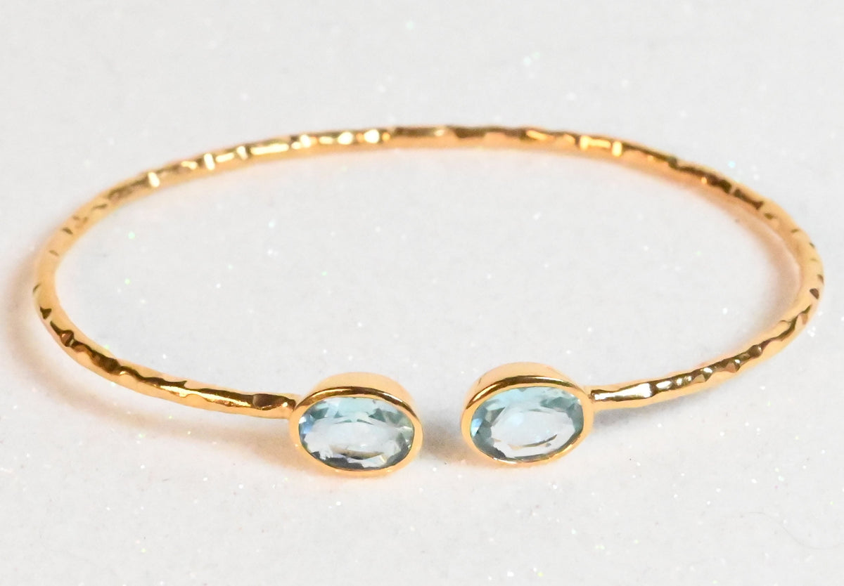 Rose-toned Euro Gold cuff bangle with two pale blue topaz gems