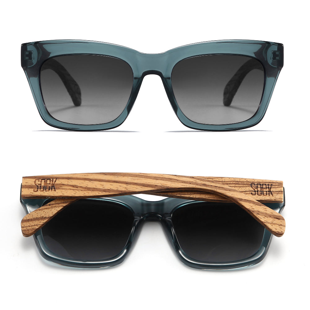 Two pairs of Morgan sunglasses in indigo blue, one front-on and one folded, showing the grained wood arms