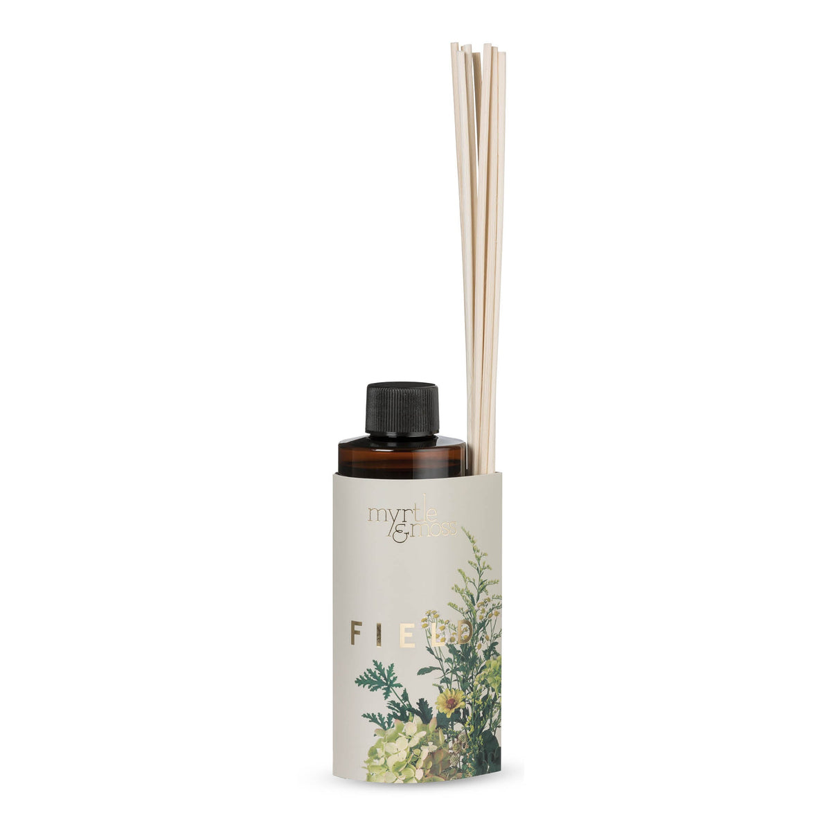 The Field refill bottle in its botanical sleeve with rattan reeds, photographed on white.