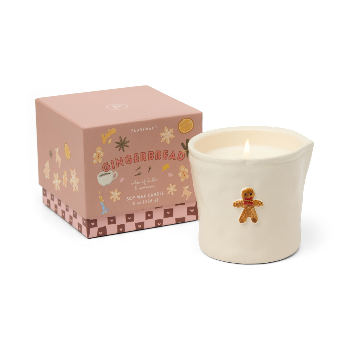 The gingerbread candle beside its dusty pink gift box printed with gingerbread biscuits and spices.