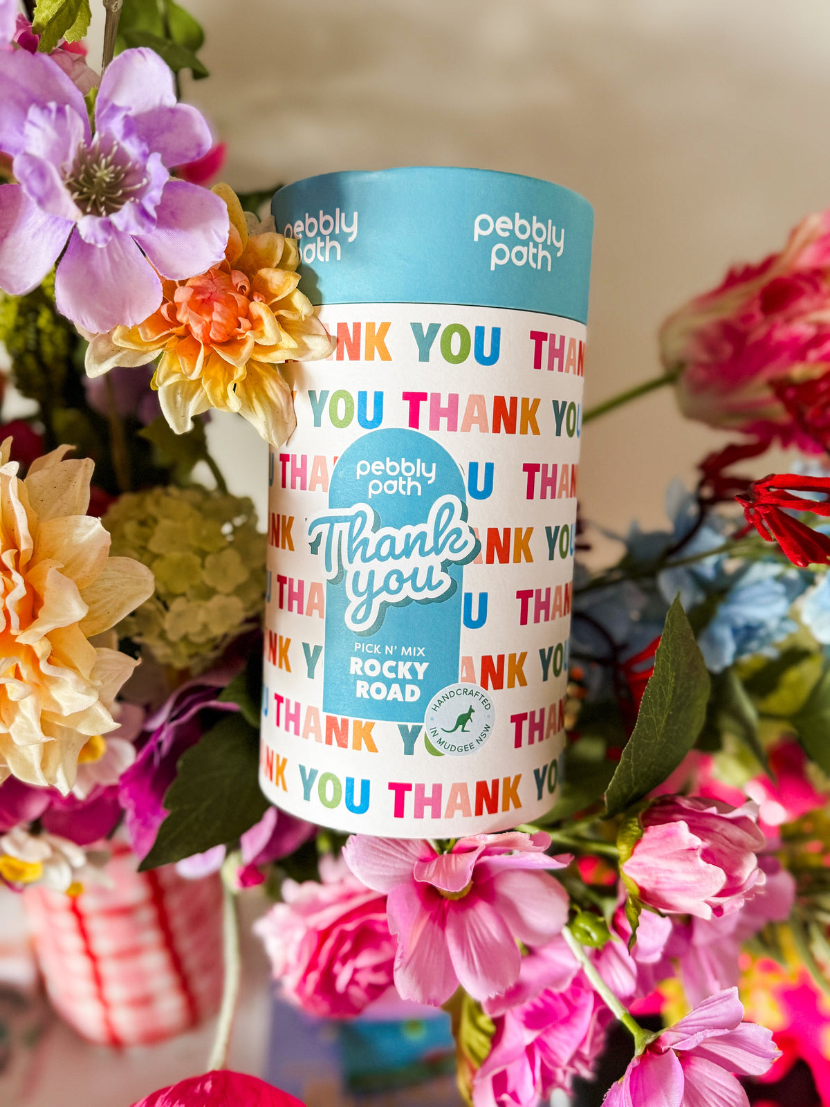Thank You rocky road gift cylinder among pink and blue flowers