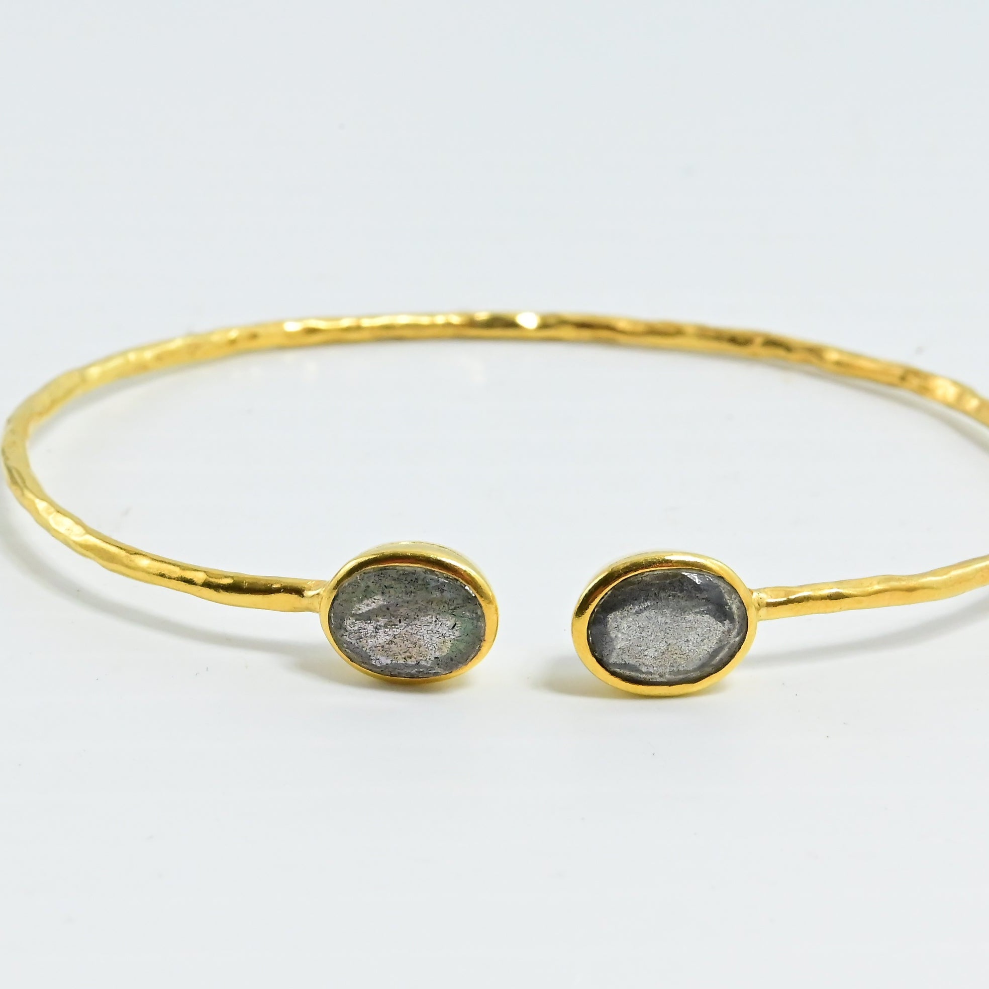 Close view of hammered Euro Gold cuff bangle with two grey oval gems