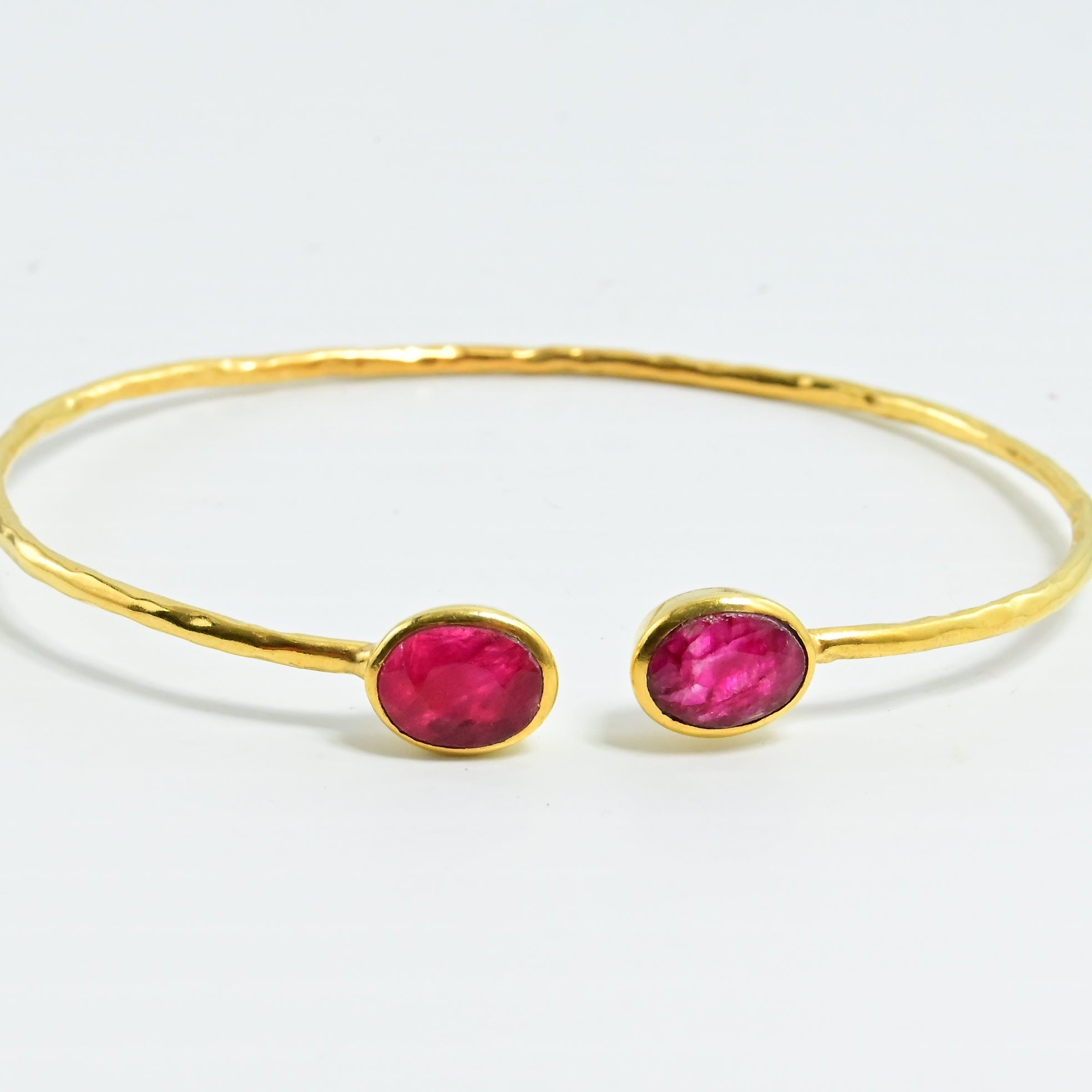 Euro Gold cuff bangle with two ruby-pink oval gems facing each other