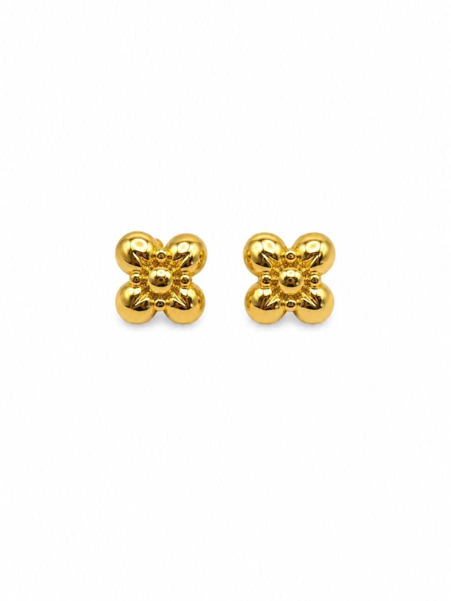 Pair of shiny gold-tone flower studs with four domed petals around a beaded centre, on white