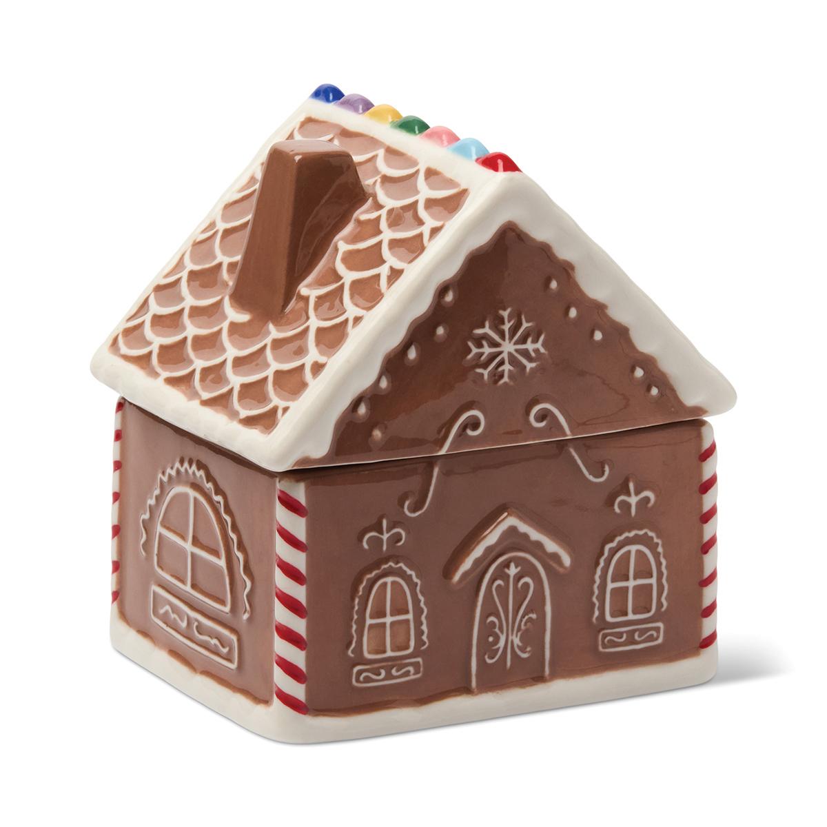Ceramic gingerbread house candle with white piped icing, a scalloped roof, a chimney and coloured sweets along the ridge.