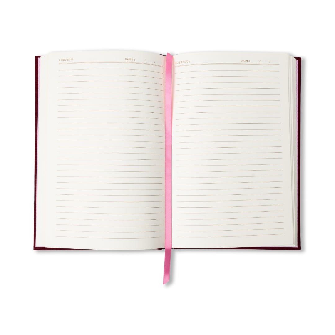The journal open to its lined ivory pages, with the pink ribbon marker