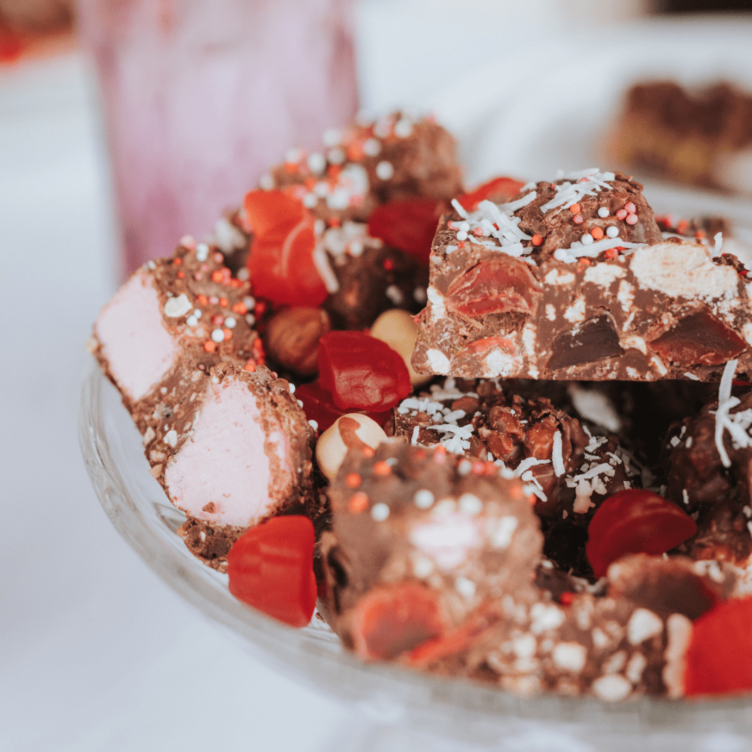 Close-up of Lovers Lane rocky road chunks with marshmallow, raspberry lollies and freeze-dried raspberry on a glass stand