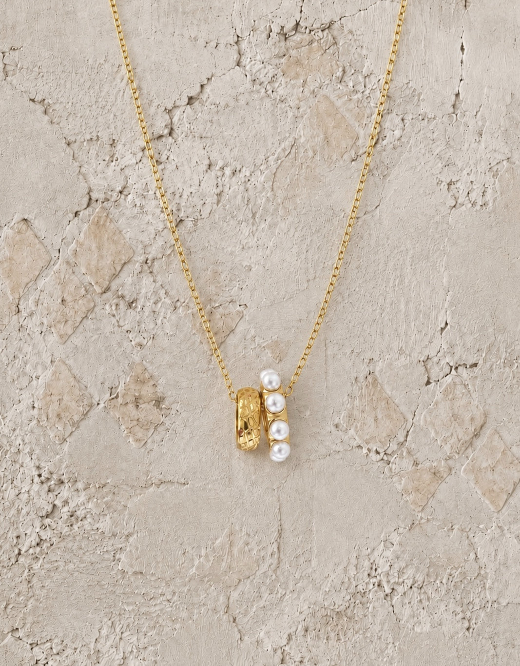 Fine gold chain necklace with a wide gold bead pendant set with a row of small white pearls