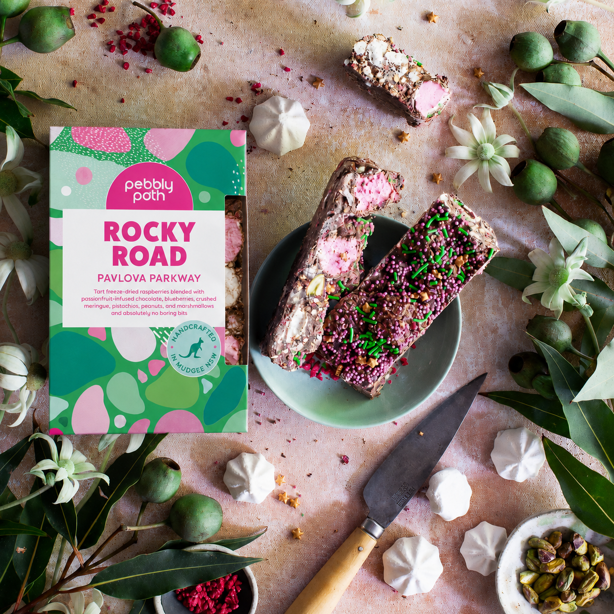 Pavlova Parkway rocky road box with slices on a plate, meringues, pistachios and gum nuts, seen from above