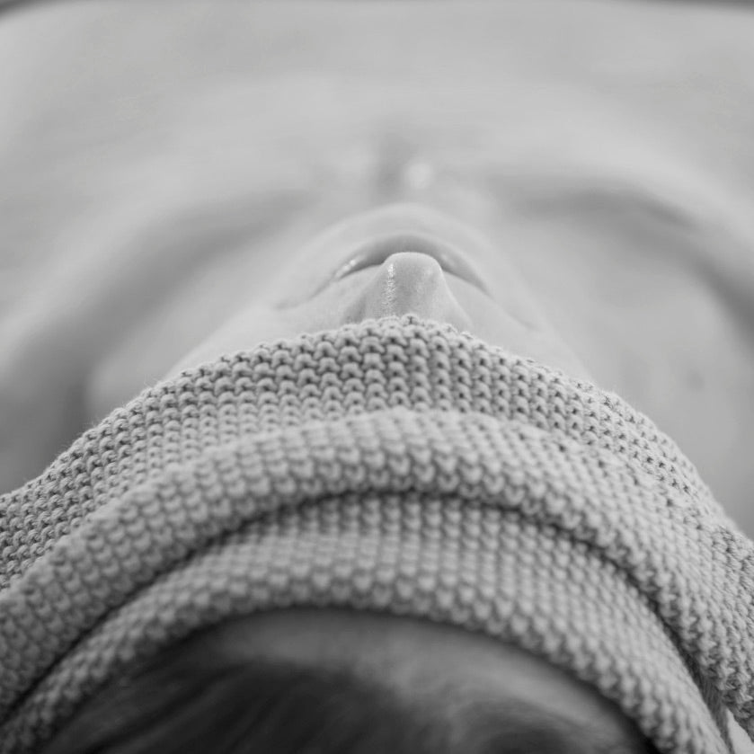 Woman relaxing with a rolled Salus cotton wash cloth across her eyes