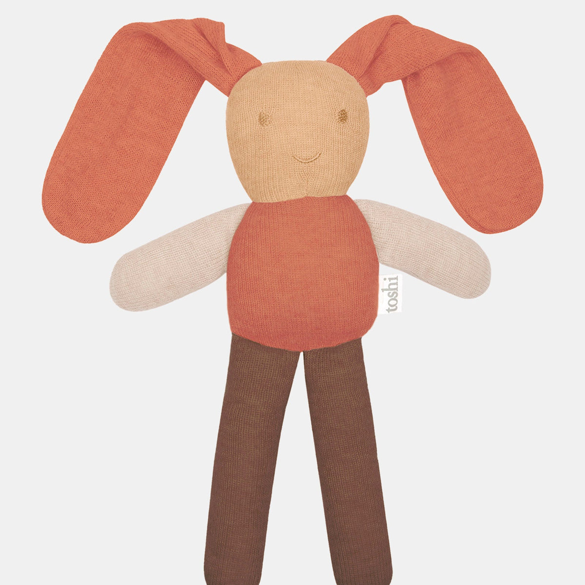 Toshi Bunny Bobby knitted comforter in oatmeal — long floppy terracotta ears, a wheat face with an embroidered smile, cream arms and chocolate legs
