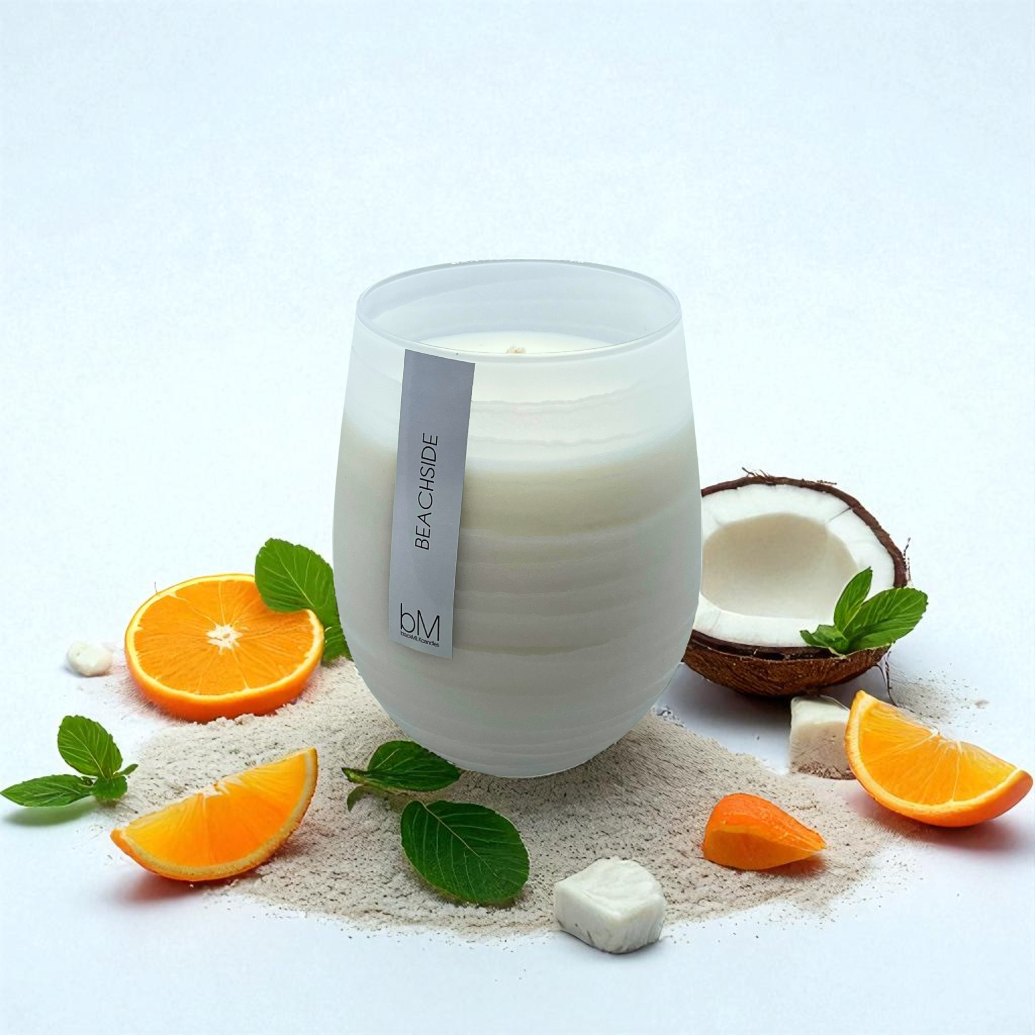 Wave White Beachside candle with orange slices, fresh coconut, mint leaves and soft sand — the fragrance notes
