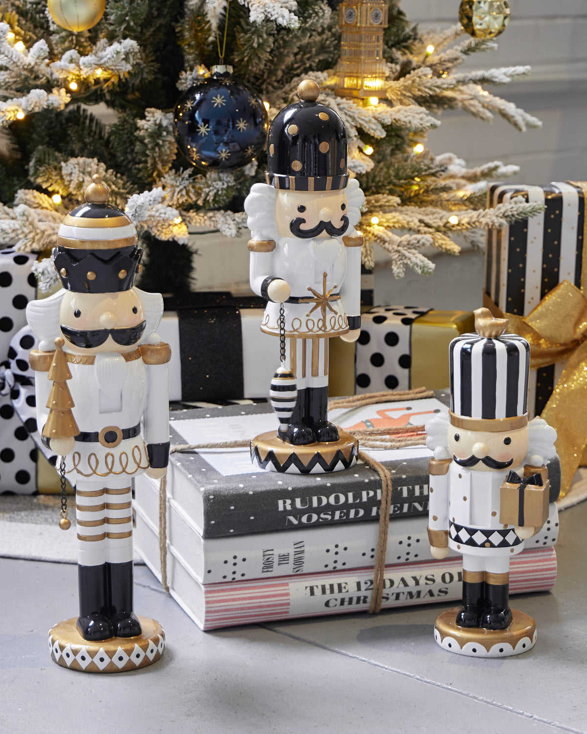 The Christmas book stack styled under a decorated tree with black and white nutcrackers