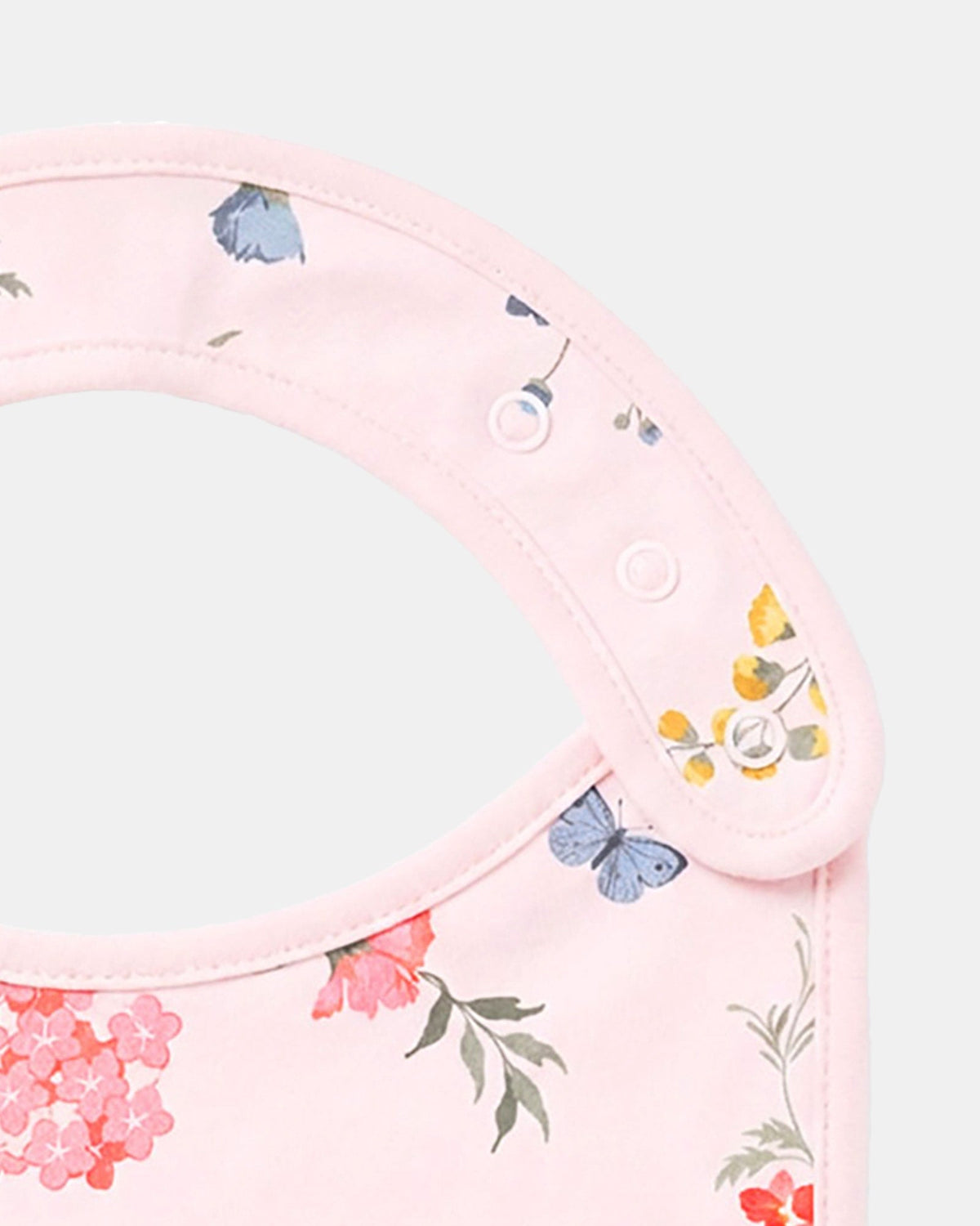 Close-up of the press-stud neck tab with florals and a blue butterfly