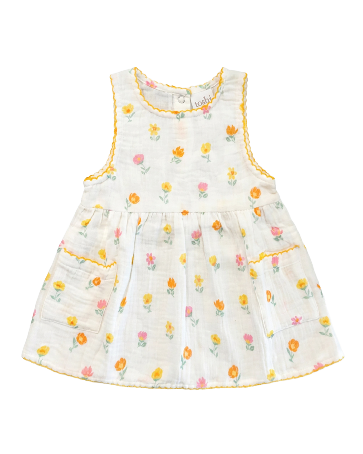 Toshi Pippa sleeveless baby dress in vanilla cotton with a small yellow, orange and pink blossom print, yellow trim and two pockets