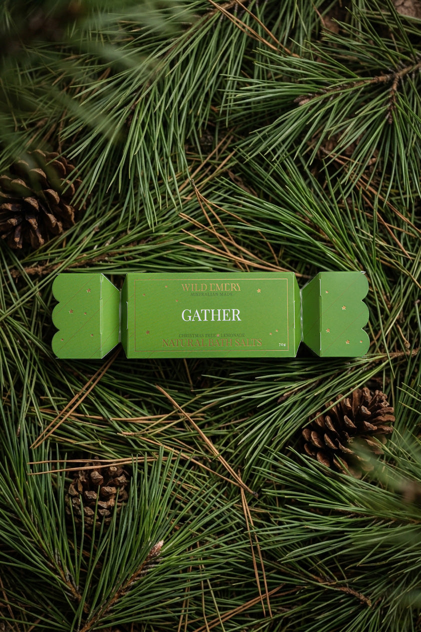 The Gather bon bon on a bed of pine needles and pine cones.