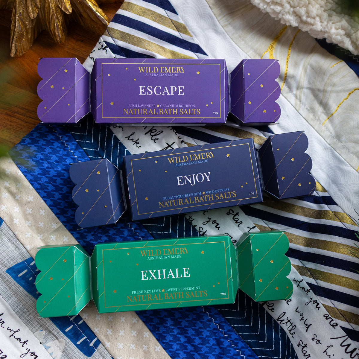 The three bon bons from the set, purple Escape, navy Enjoy and green Exhale, on a patchwork quilt.