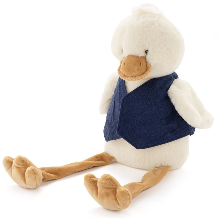 Cream plush duck with long dangly legs, sitting in a plain navy linen bib.
