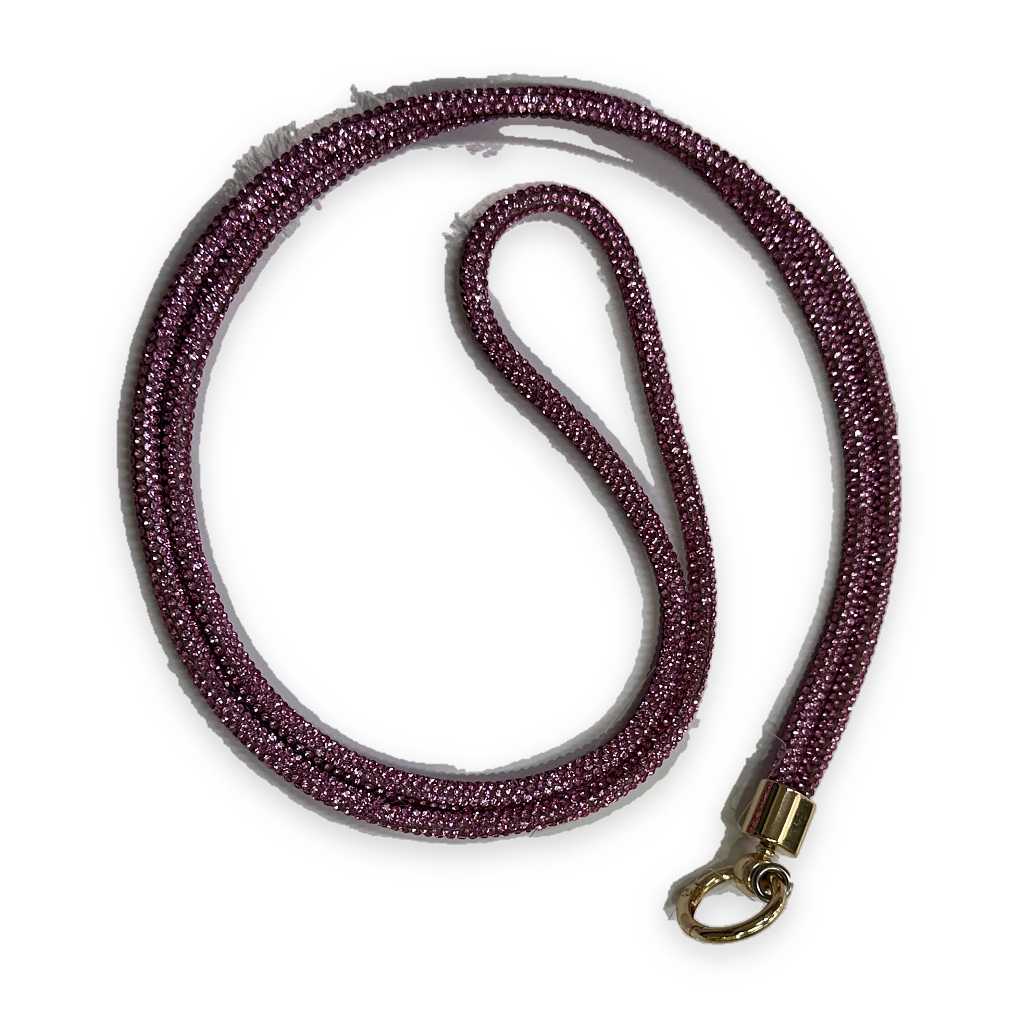 A crossbody phone lanyard coiled in a loop, the cord densely set with small fuchsia pink sparkling stones, finished with a gold-tone clasp ring.