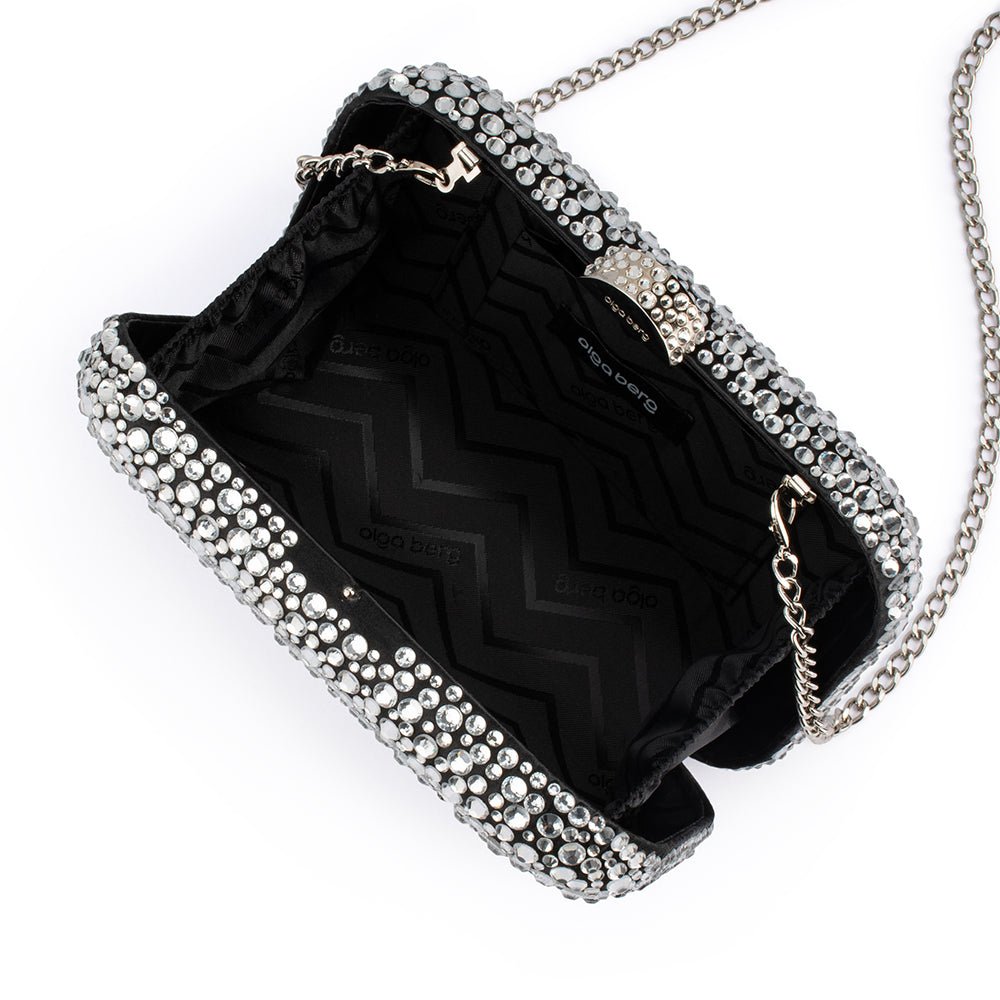 The clutch open, showing a black zigzag-patterned lining and the silver chain clipped inside