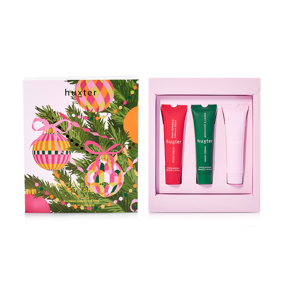 Huxter Hand Cream Trio box lid with Christmas baubles and pine, beside the open box holding red, green and pale pink tubes.