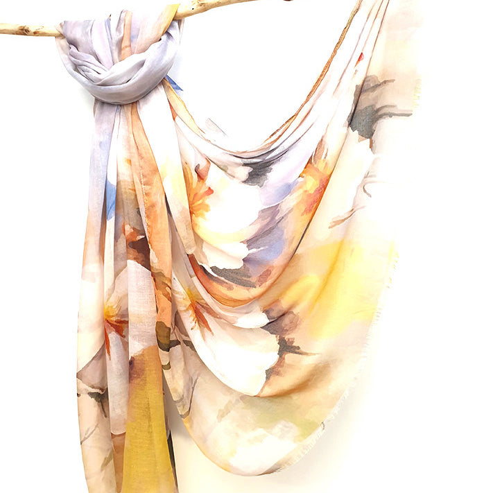 Apricot Watercolour cotton viscose scarf knotted over a branch, watercolour blooms in cream, apricot and yellow