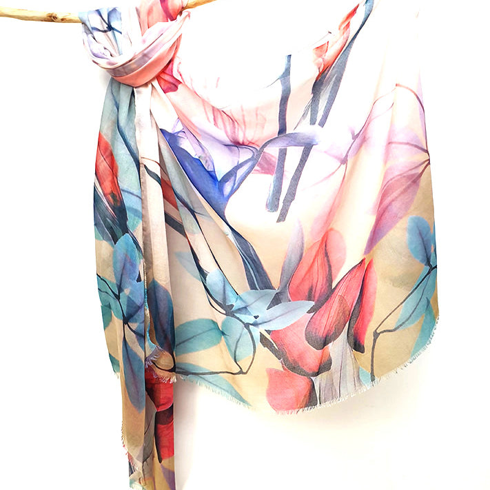 Coral and Teal Floral cotton viscose scarf knotted over a branch, coral, teal and blue painted flowers on a white to sand ground