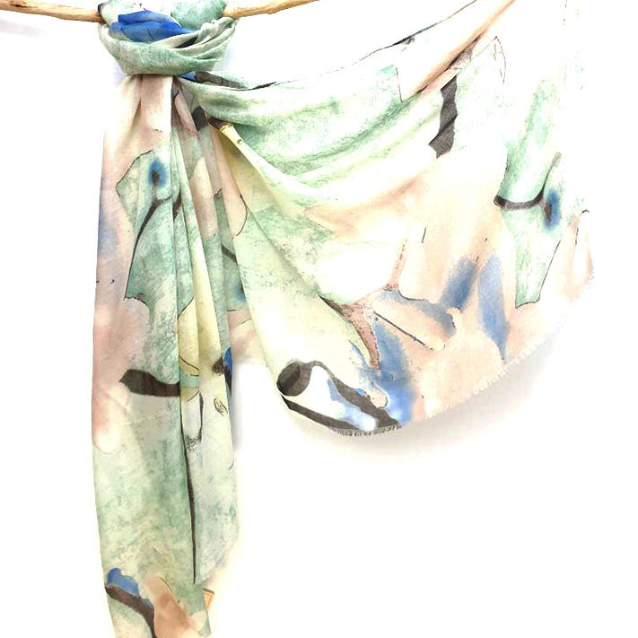 Mint Watercolour cotton viscose scarf knotted over a branch, mint and peach print with blue washes and frayed ends