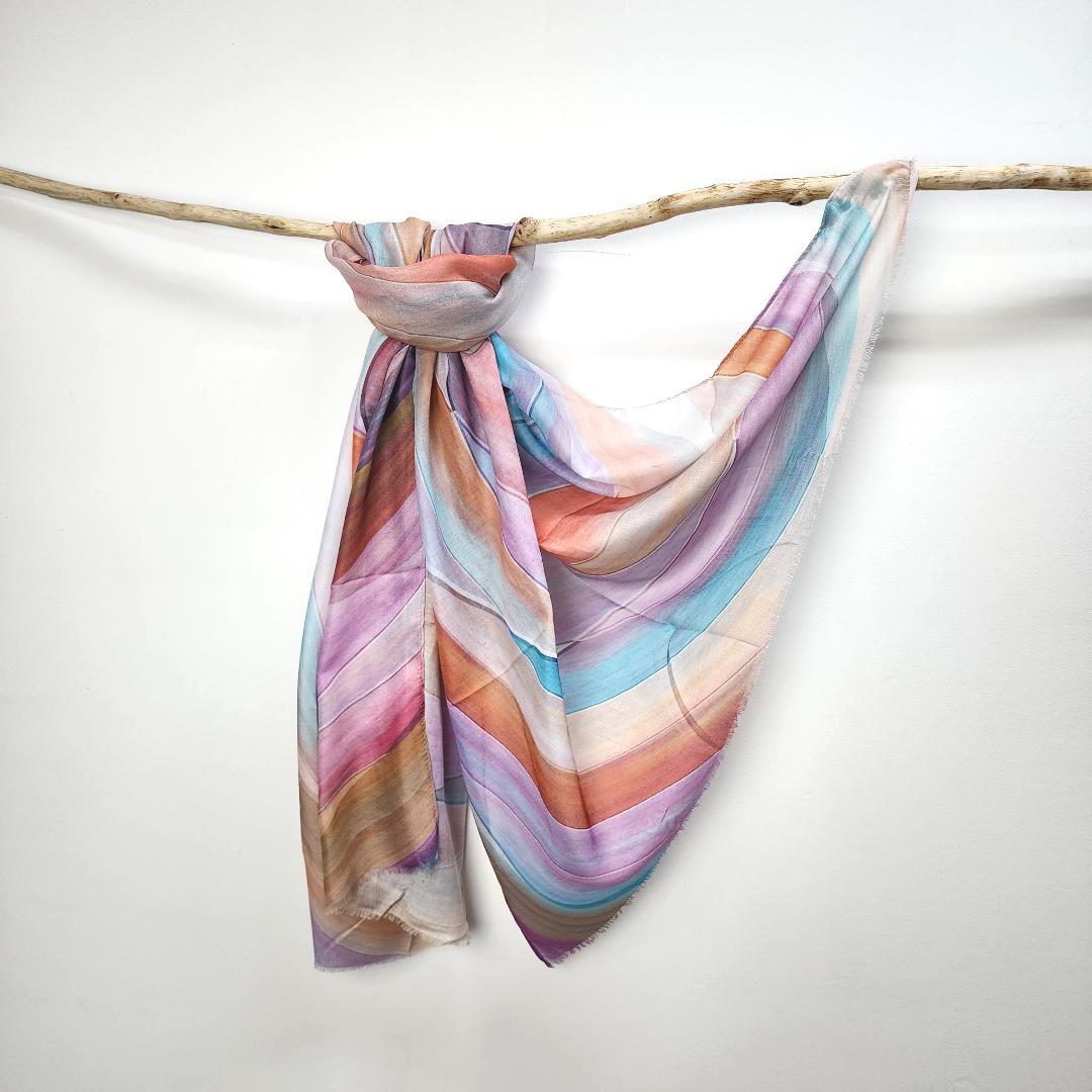 Pastel Stripe cotton viscose scarf knotted over a branch, painted stripes in lilac, sky blue, coral, peach and caramel