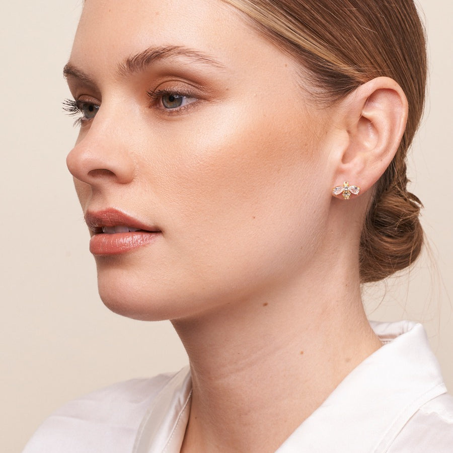 Model in a white shirt wearing the gold bee stud earring