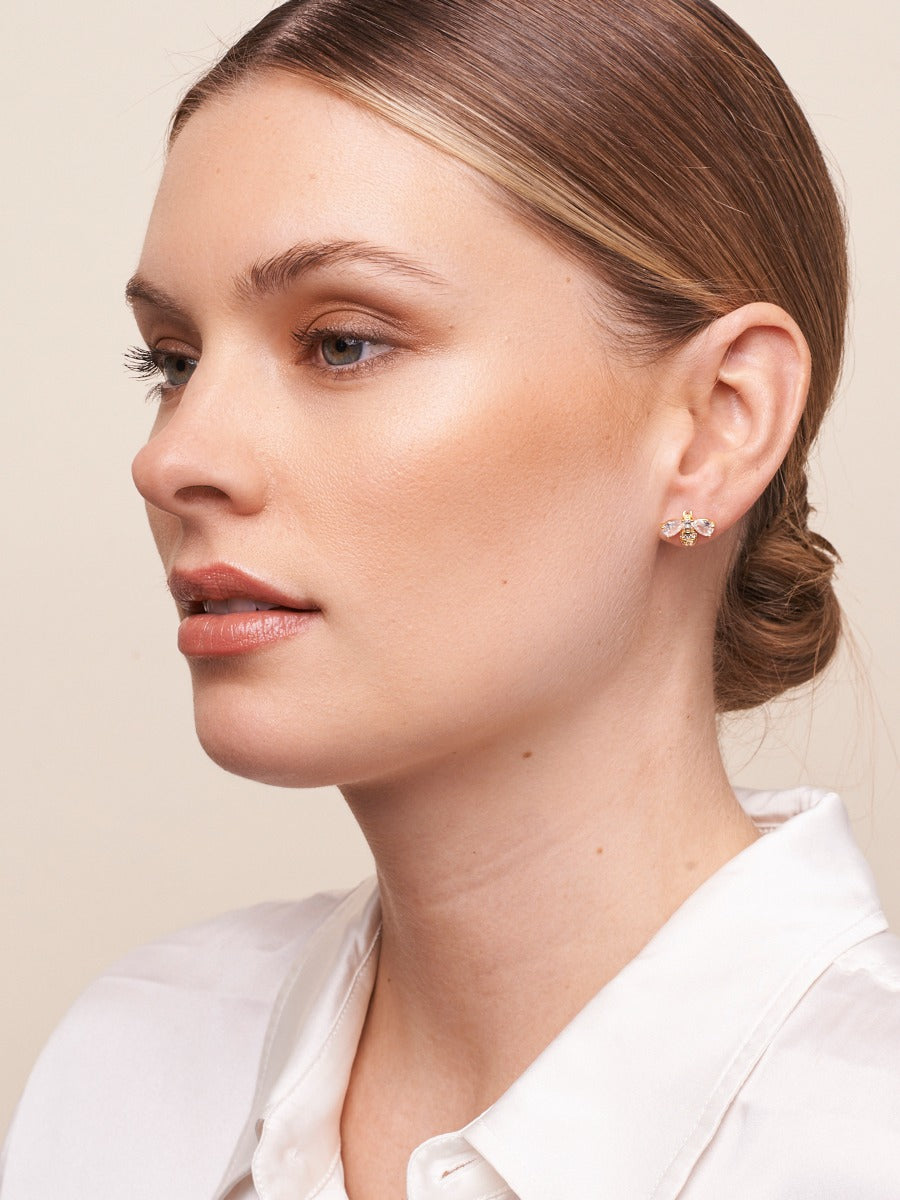 Model in a white shirt wearing the gold bee stud earring