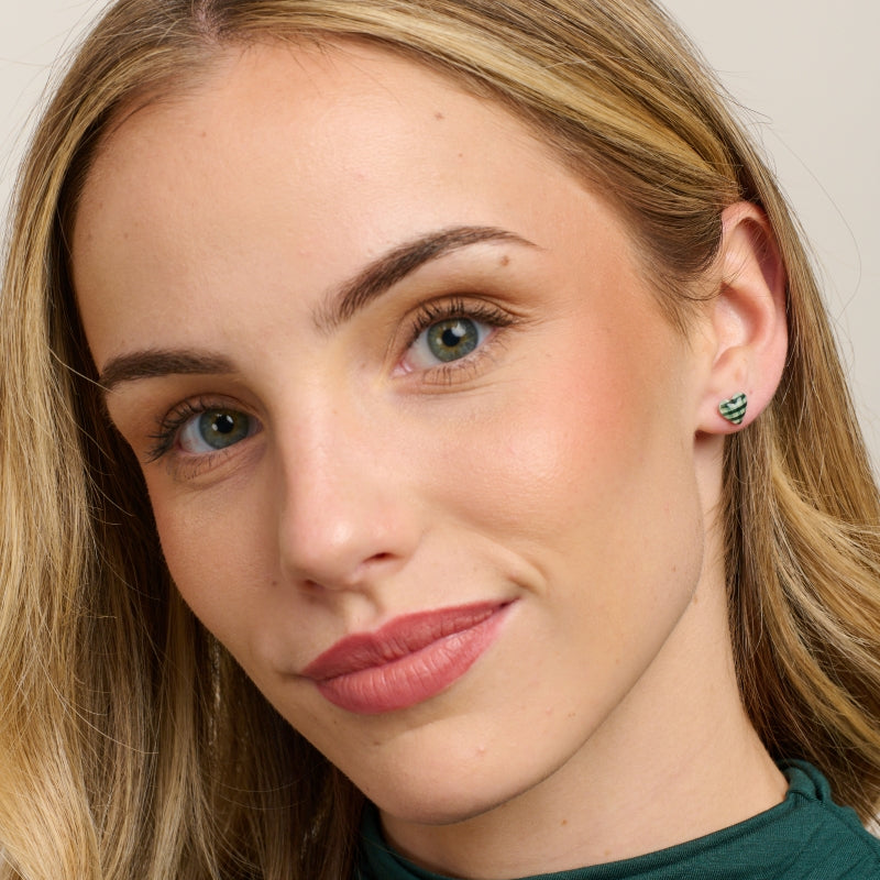 Model in a green top wearing the green gingham heart studs