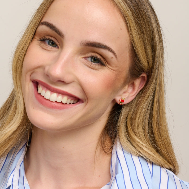 Smiling model in a striped shirt wearing the apple stud earrings