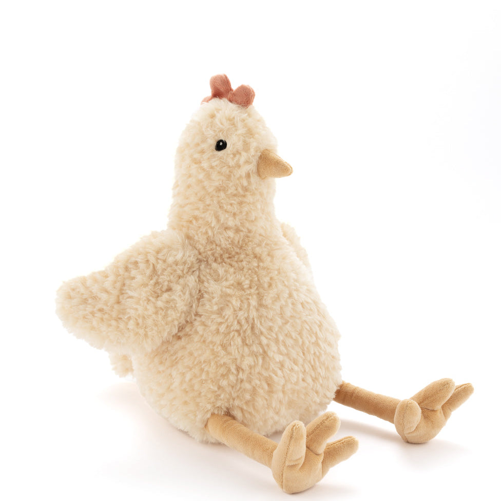 Plush hen in shaggy honey-coloured fur with a red comb and long golden legs, sitting with her legs out in front.