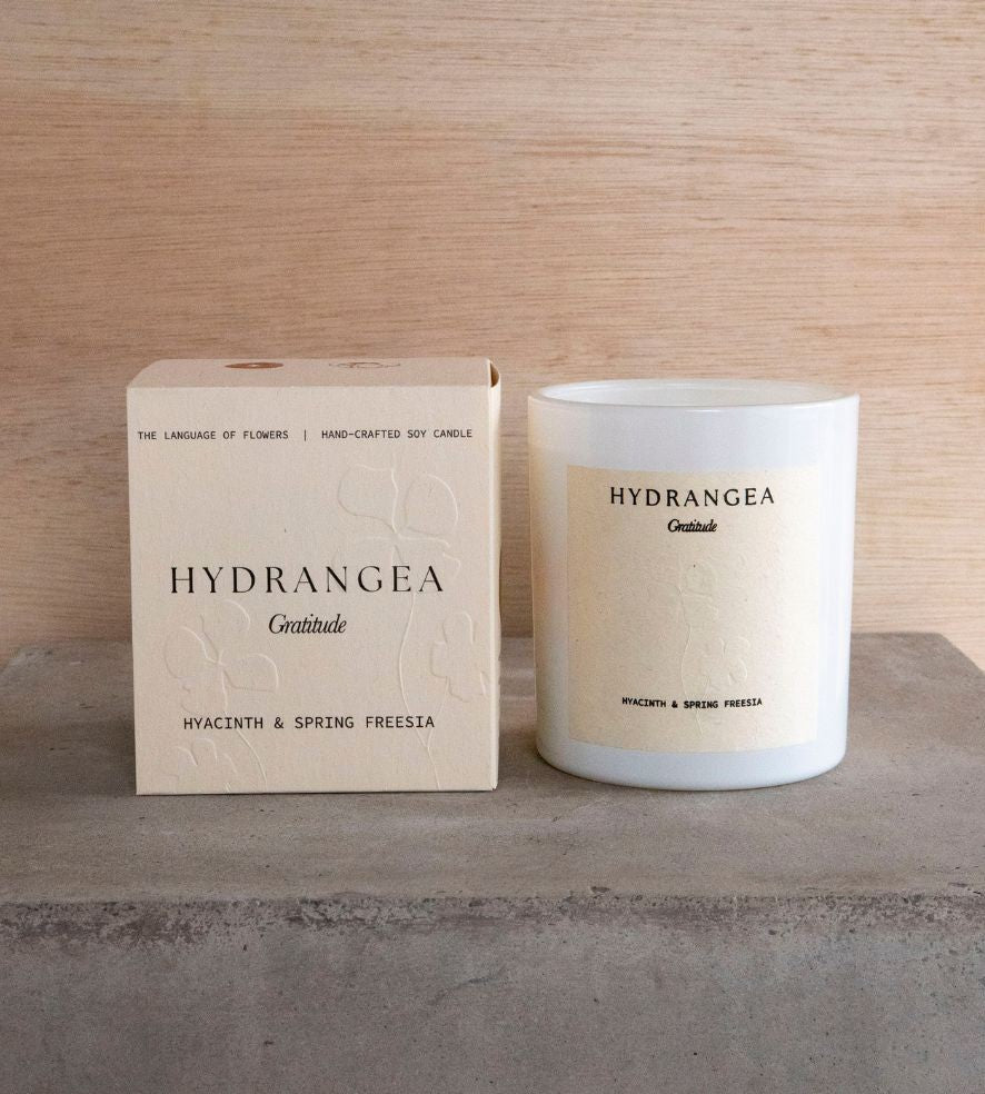 The Hydrangea candle and its box on a concrete plinth.