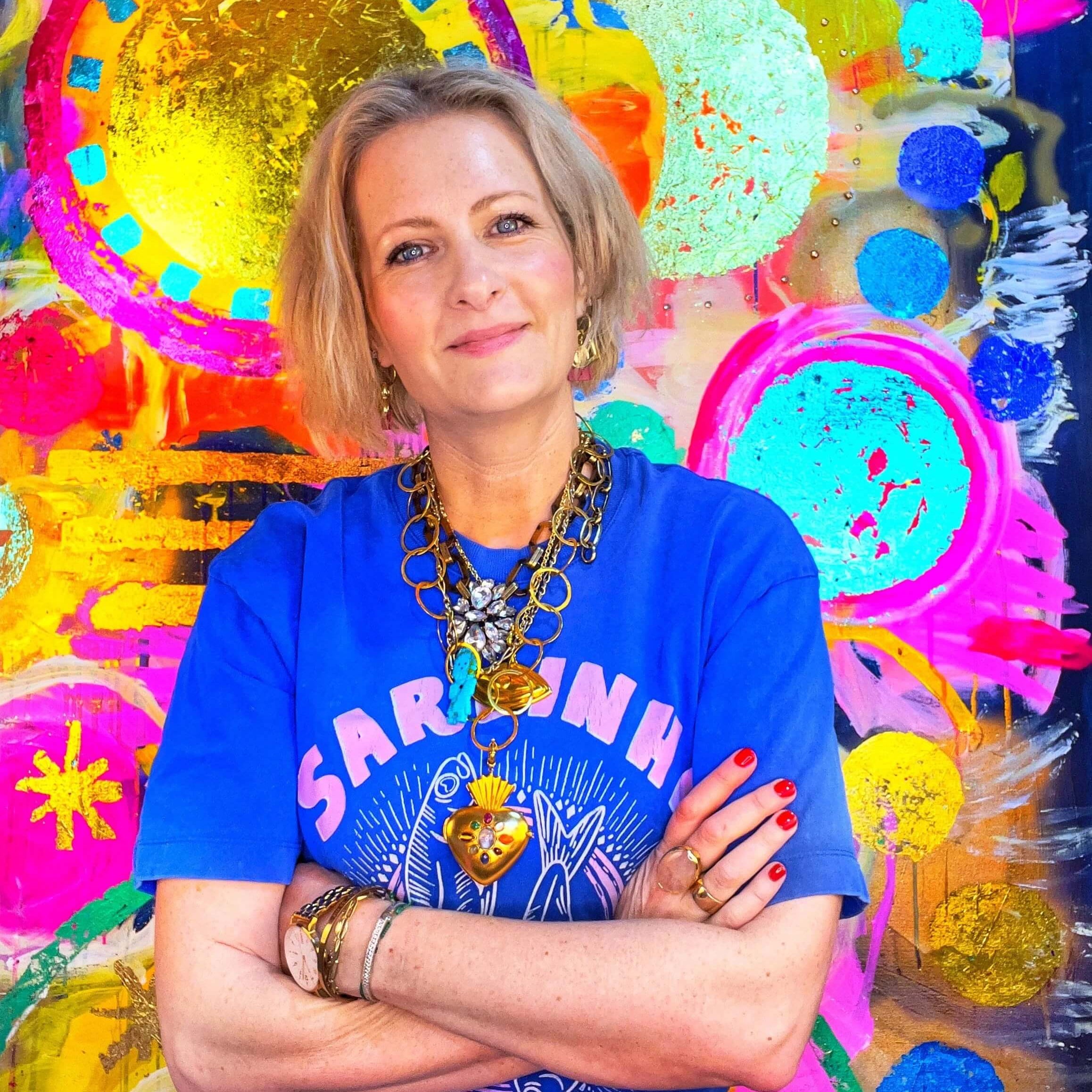 Artist Louisa de Haas standing in front of her colourful artwork