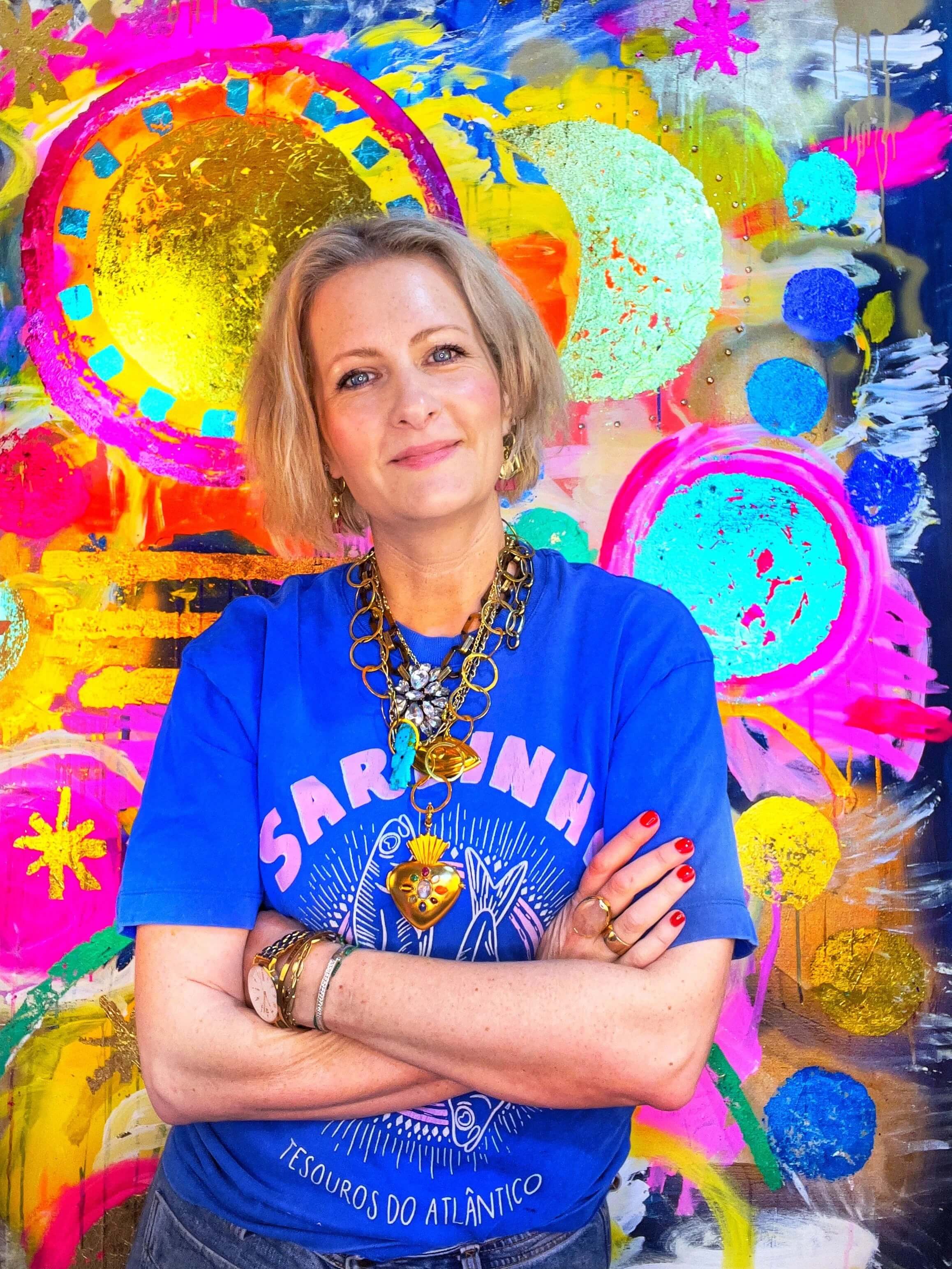 Artist Louisa de Haas standing in front of her colourful artwork